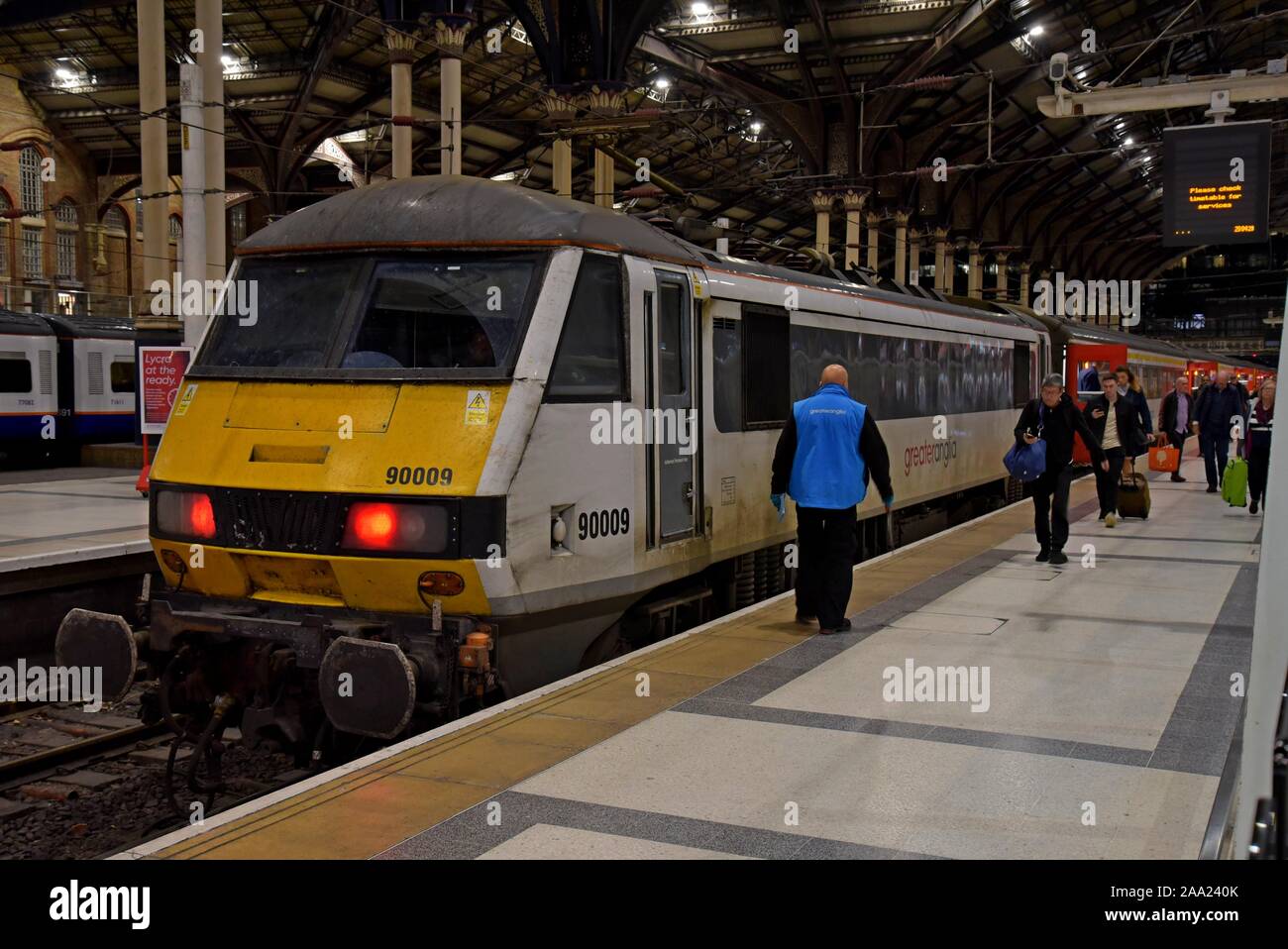 Il passeggero di lasciare il treno alla stazione di Liverpool Street, Londra. Il locomotore è un British Rail classe costruito 90 electric loco Foto Stock