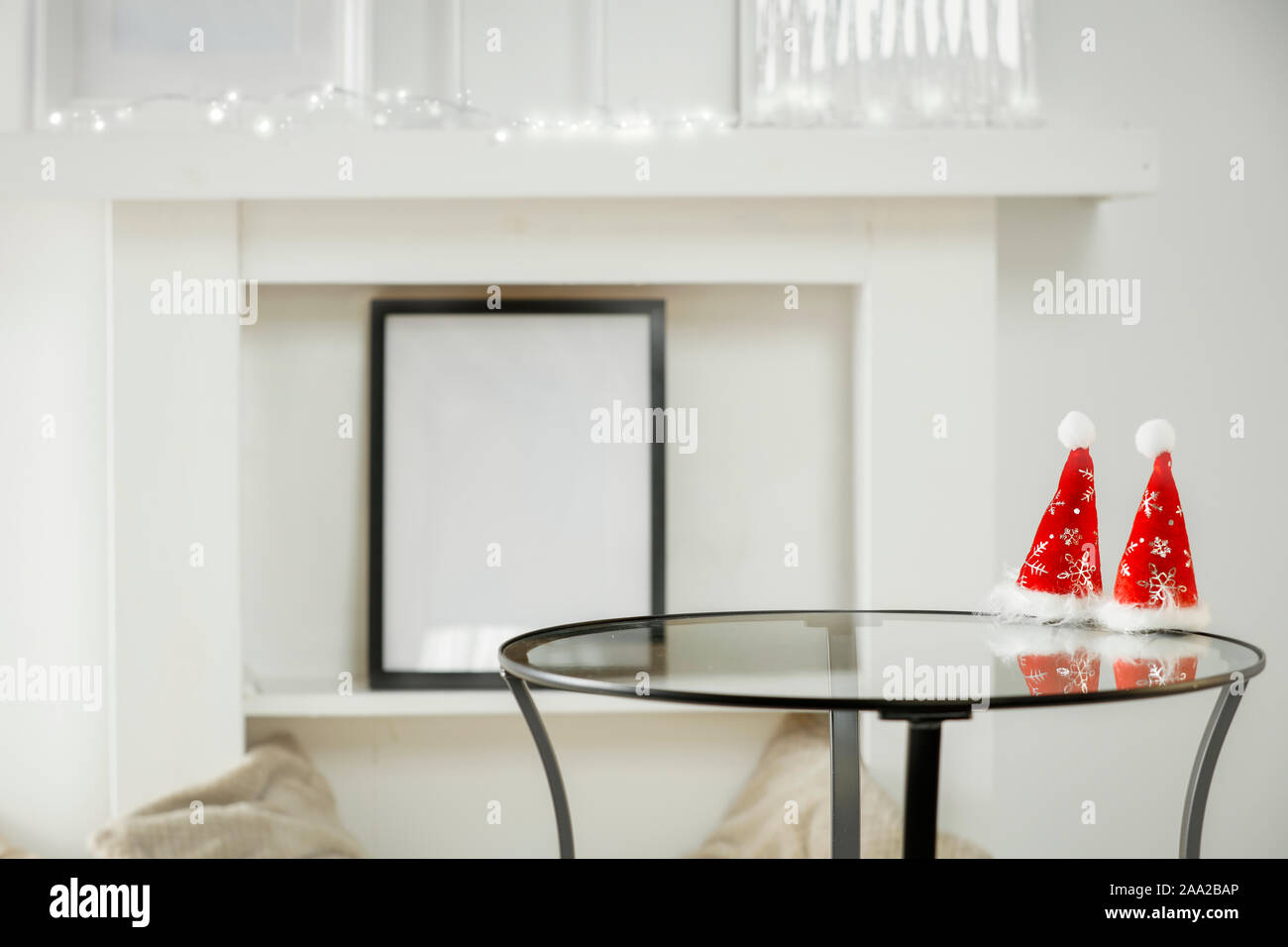 Tavolo con decorazione di Natale e muro bianco sullo sfondo luminoso in accoglienti interni di lusso. Foto Stock