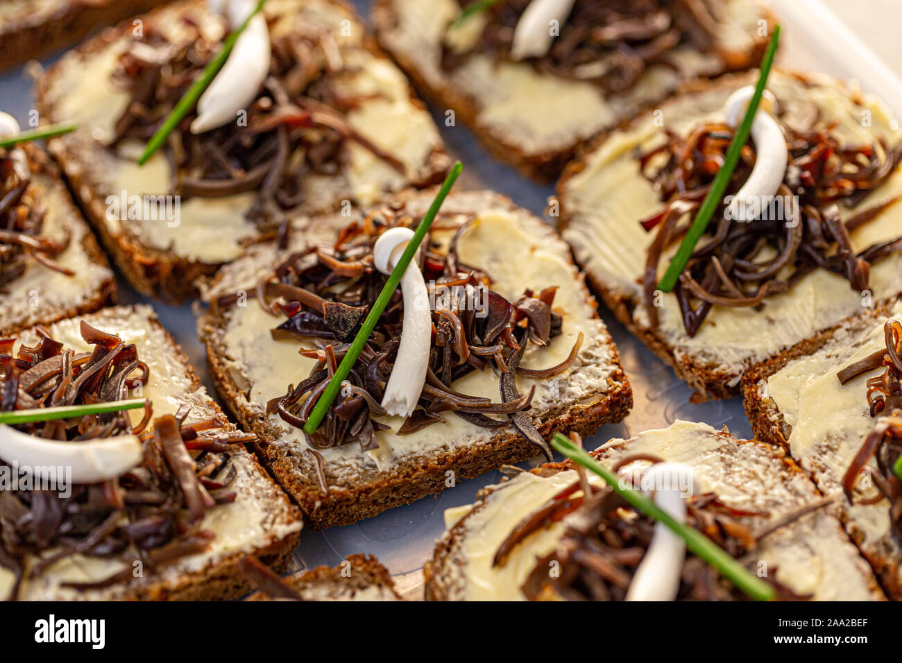 Fette di pane fresco con burro decorate con legno marinato orecchio commestibili e di funghi shimeji Foto Stock