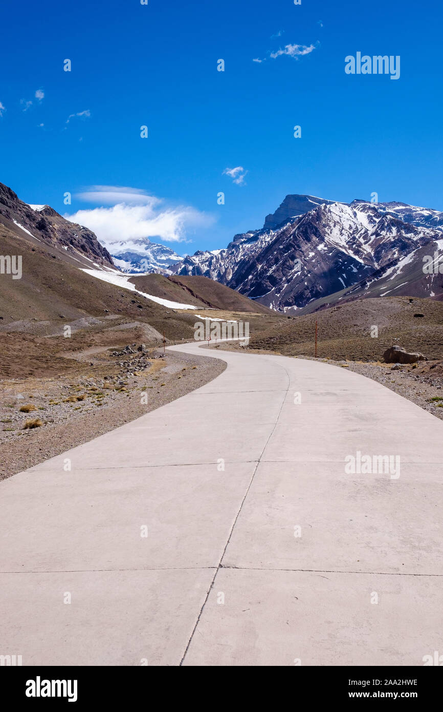 Alta strada di montagna al Parco Aconcagua con il Monte Aconcagua in background, provincia di Mendoza, Argentina Foto Stock