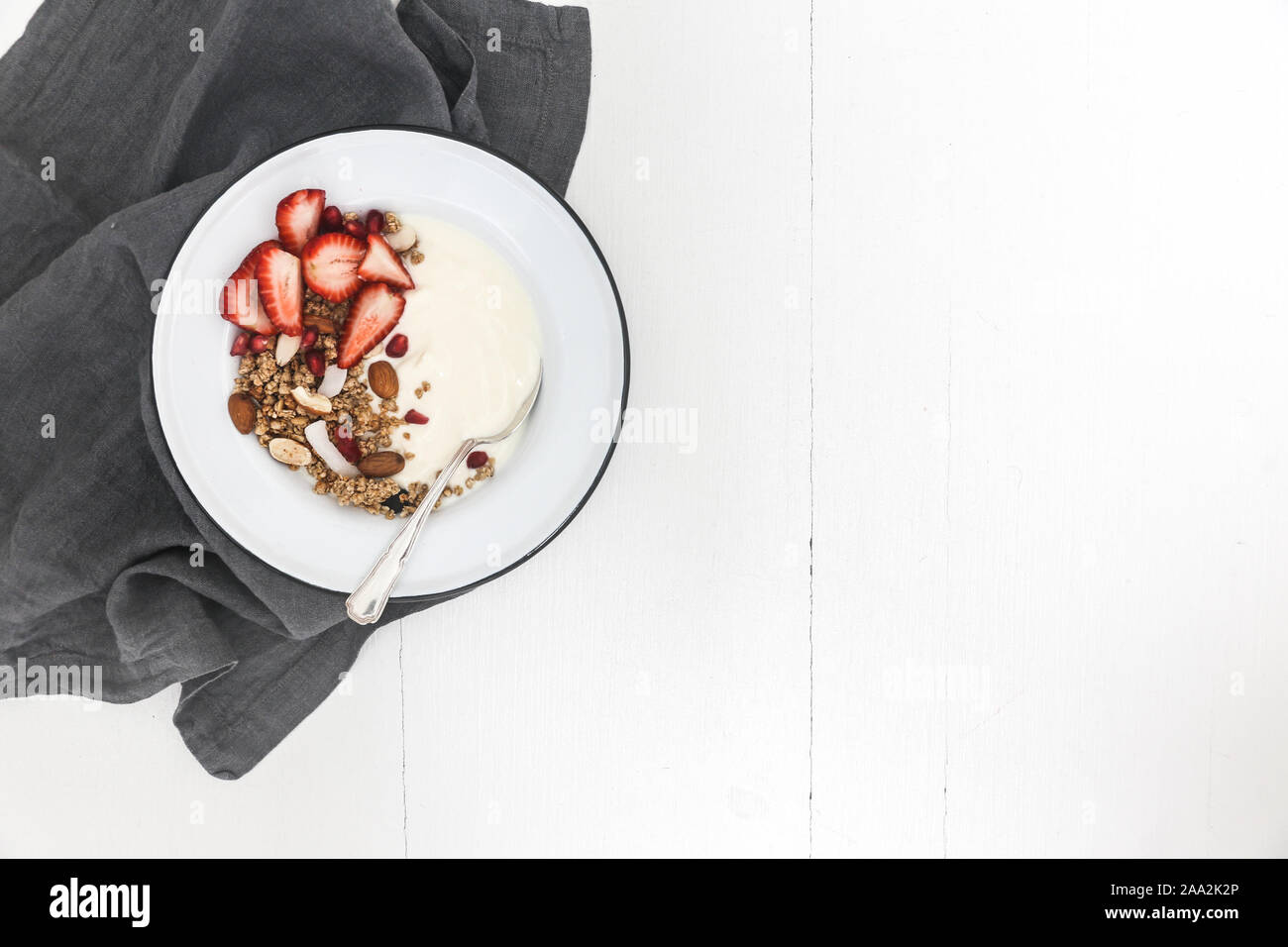 Yogurt e muesli con fragole fresche, melograno e mandorle Foto Stock