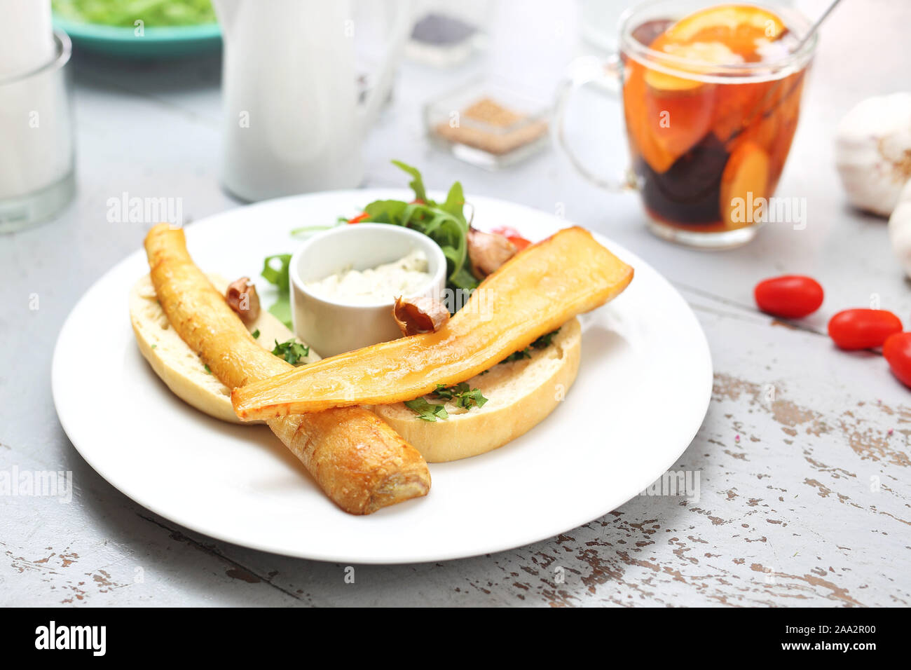 La cucina vegetariana. Arrosto di corteccia di prezzemolo in salsa di miele servita su pane tostato. Rucola e Pomodorini insalata con salsa di aglio. Foto Stock