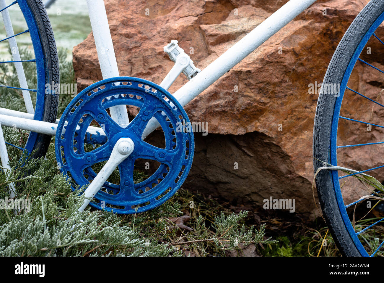 Parti di una bicicletta in piedi nel giardino come decorazioni dipinte di blu e bianco Foto Stock