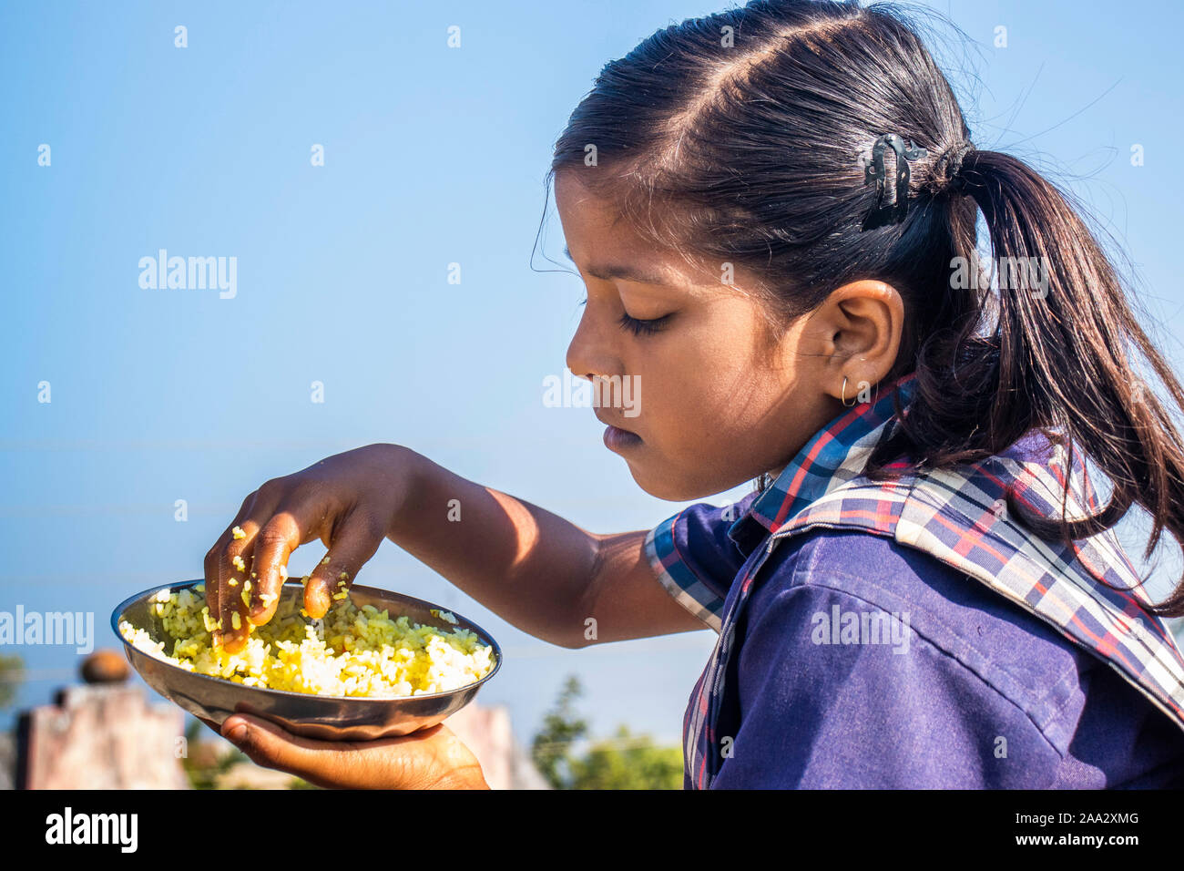 Sijhora,Madhya Pradesh,India-November 19, 2019 :Close up verticale carino Indian School girl sono a mangiare cibo. in India Foto Stock