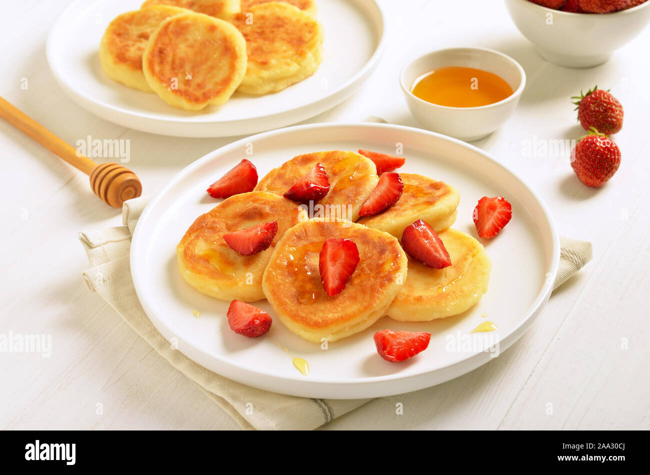 Cottage cheese pancake con fette di fragola e miele. Una sana prima colazione Foto Stock