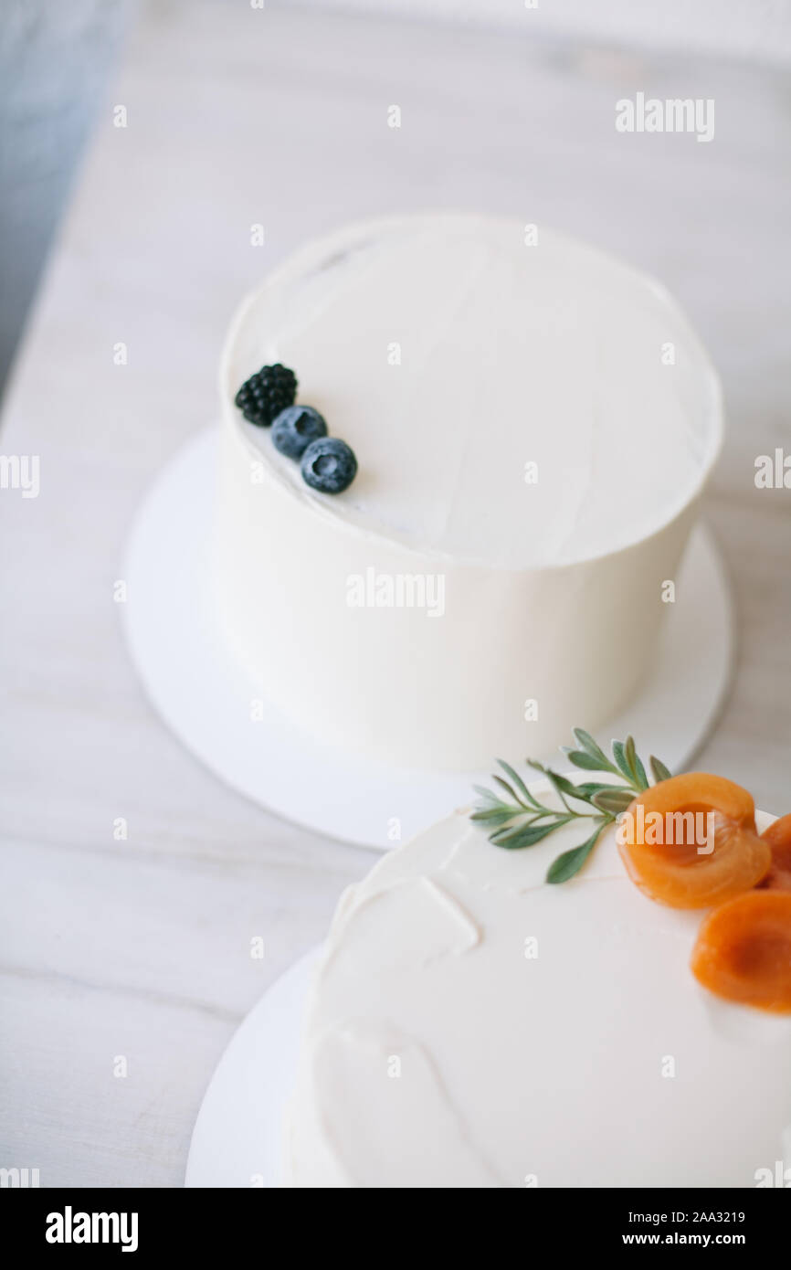 Torte decorate con glassa di crema di burro e frutta Foto Stock