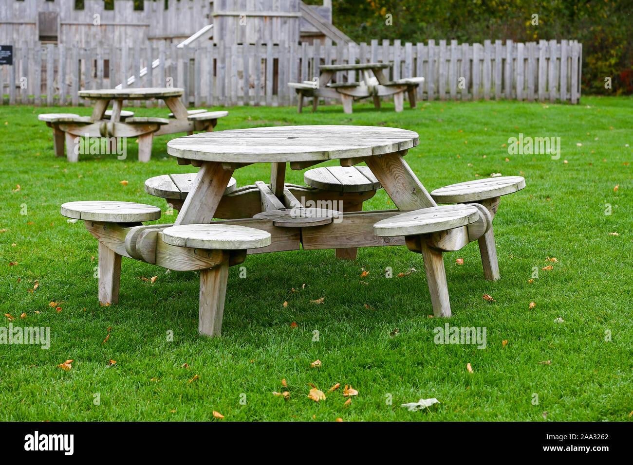 Legno tavoli da picnic su un prato con nessuno seduto alla loro, England, Regno Unito Foto Stock