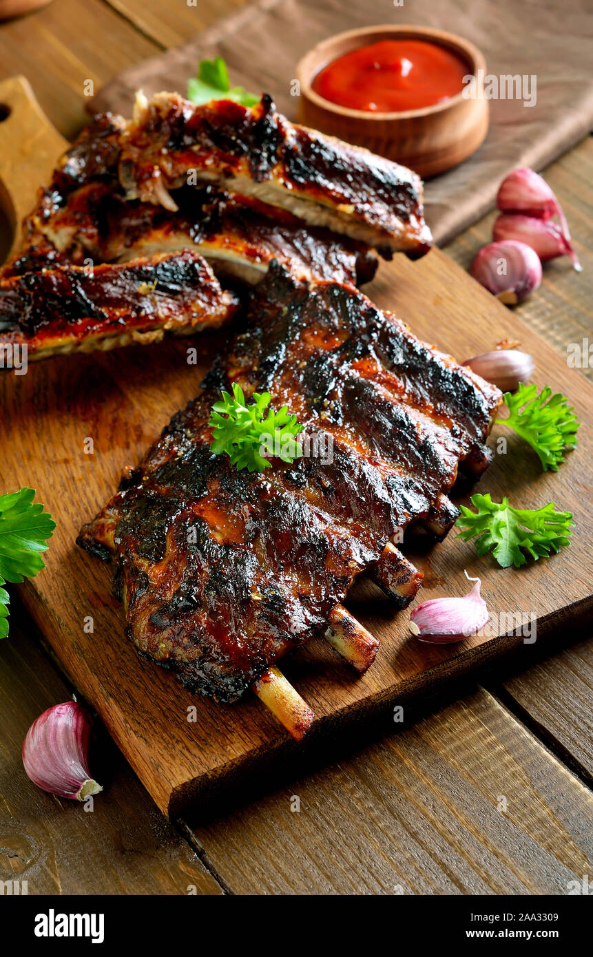 Grigliata di costolette di maiale sul tagliere. Gustosi barbecue di carne Foto Stock