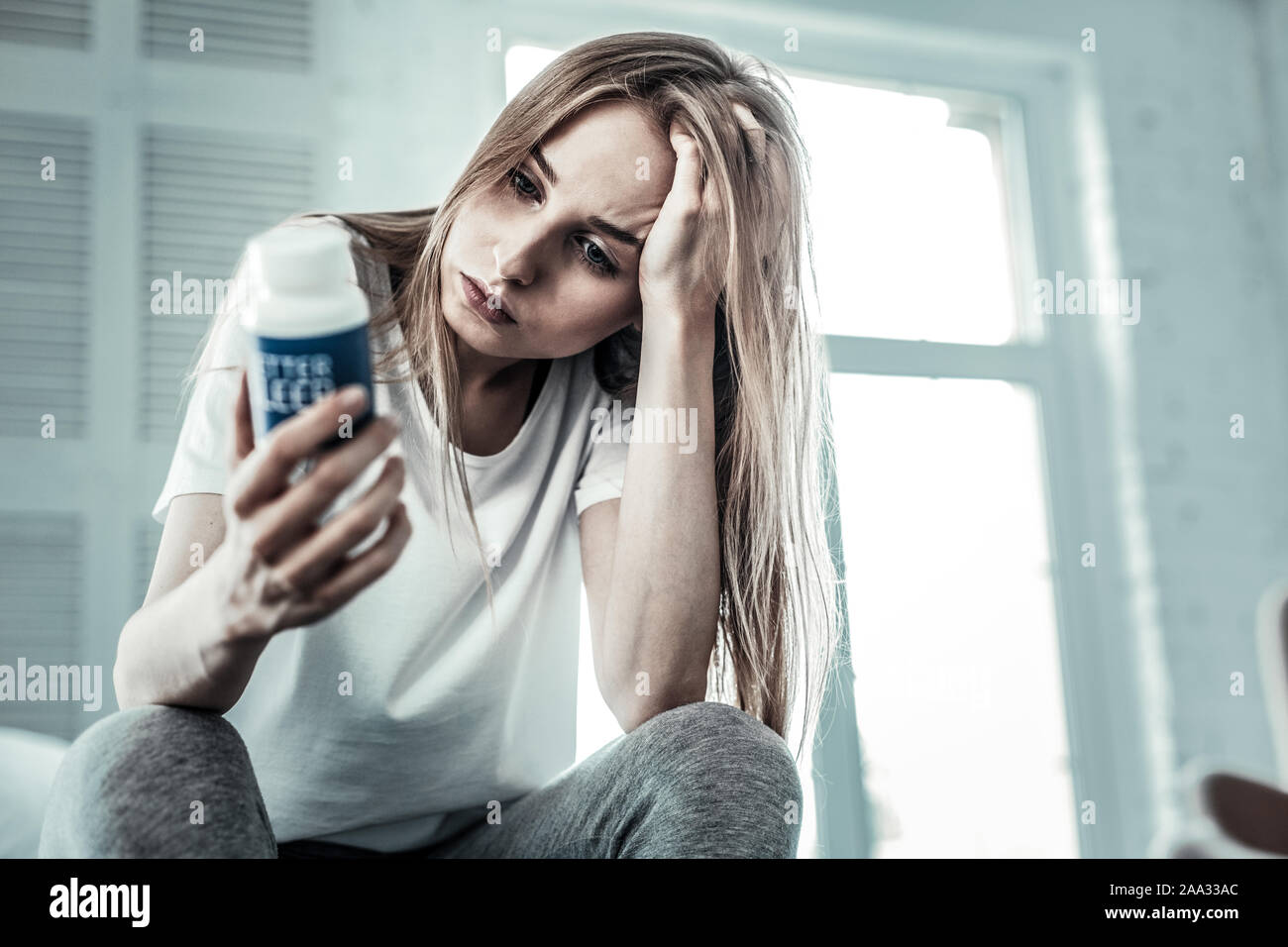 Premuto bella giovane donna che mantiene i suoi capelli Foto Stock