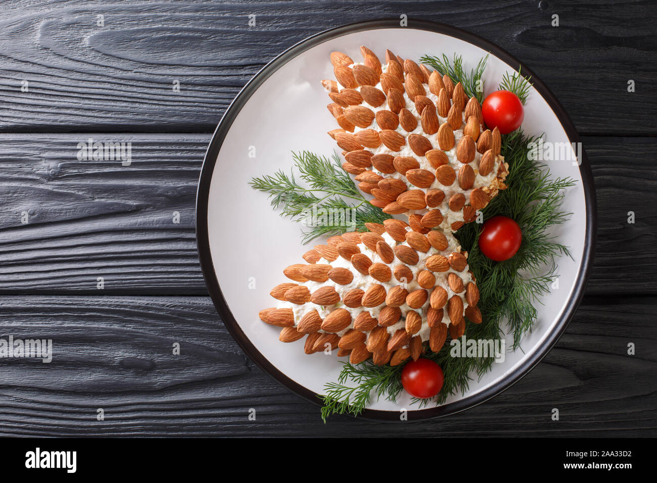 Inverno insalata formaggio antipasto con mandorle in forma di coni di pino close-up su una piastra sul tavolo. Parte superiore orizzontale vista da sopra Foto Stock
