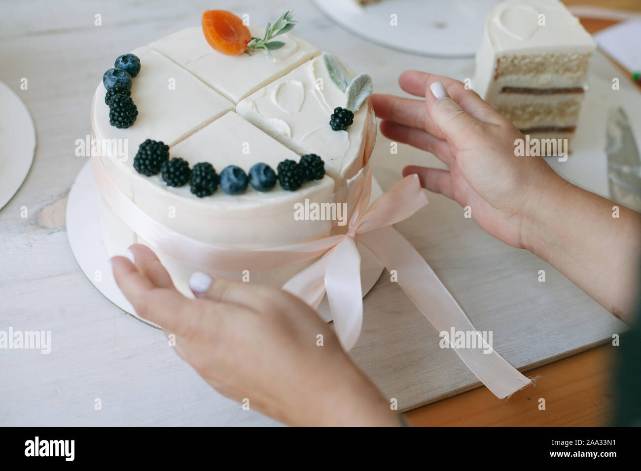 Donna mettendo insieme quattro fette di torta per fare una torta di composto Foto Stock