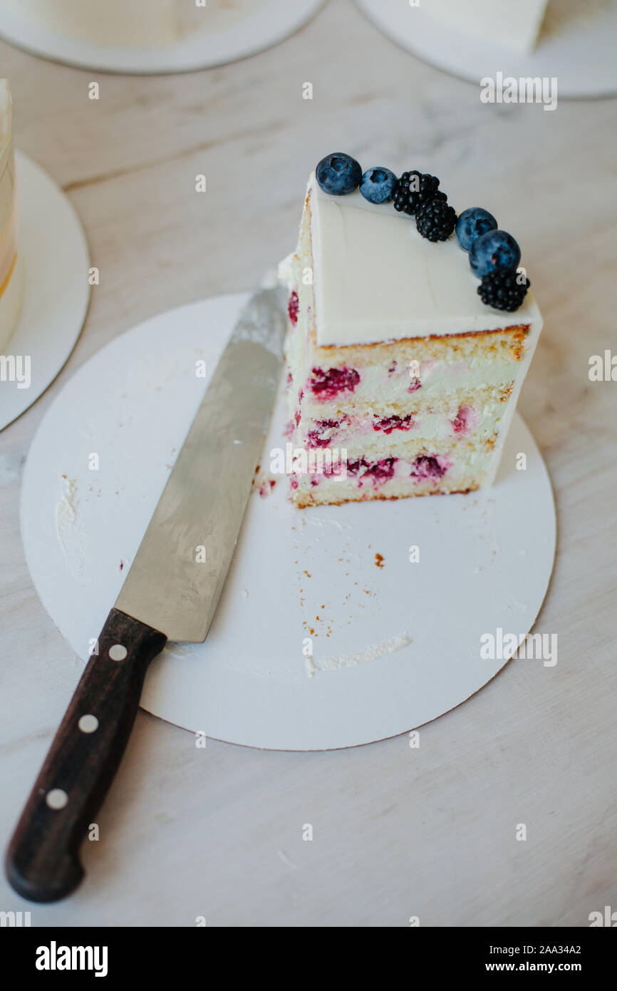 Fetta di lampone e crema di formaggio torta accanto a un coltello Foto Stock