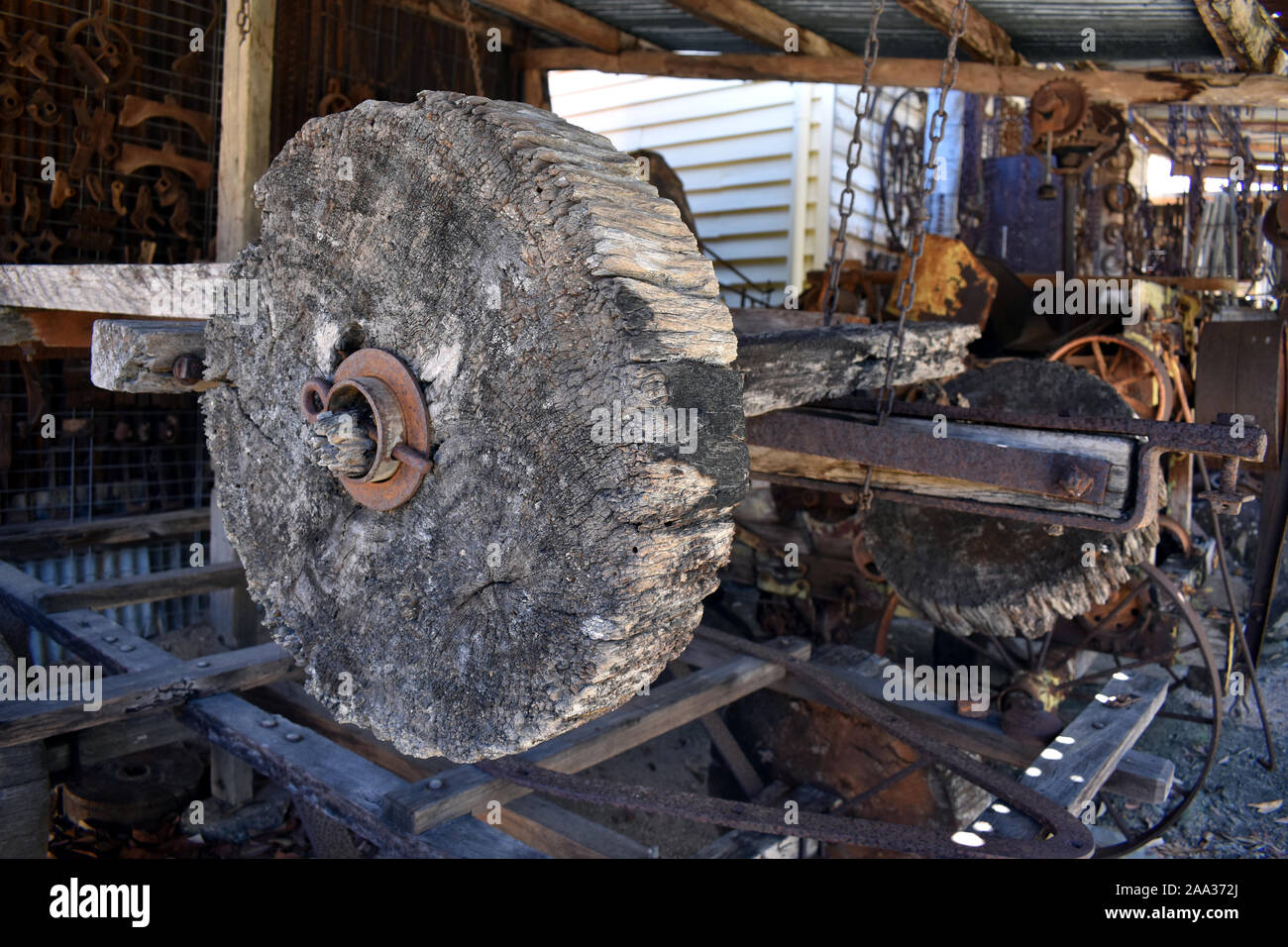 I resti di una vecchia ruota in legno su un assale situato su un vecchio carrello Foto Stock
