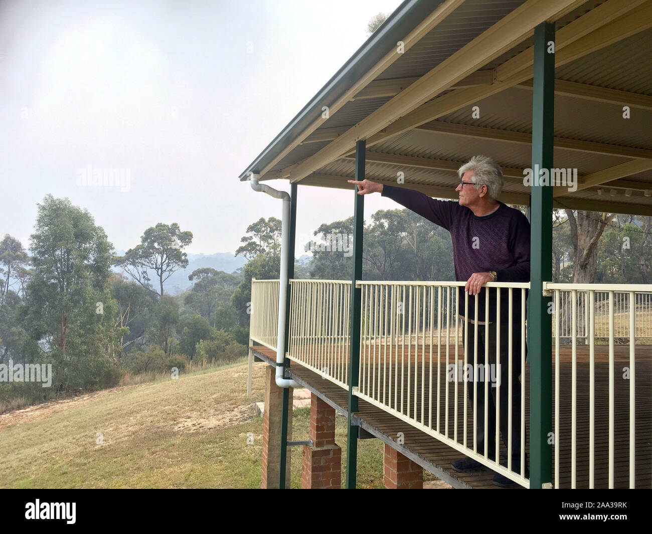 Colo Heights, Australia. Xviii Nov, 2019. Il 71-anno-vecchio Dave Davey punti dal balcone della sua casa al 'Gosper " montagna di fuoco che sta lavorando la sua via nella sua direzione. Ma il 71-year-old non dare modo. " Ho di essere qui a salvare la mia casa", Davey dice. Per 30 anni la sua casa è rimasta nella boccola in prossimità del Wollemi National Park nelle Blue Mountains, a circa cento chilometri da Sydney. (A dpa " Siamo contro natura": "Un luogo combatte contro bush incendi in Australia ") Credito: Subel Bhandari/dpa/Alamy Live News Foto Stock