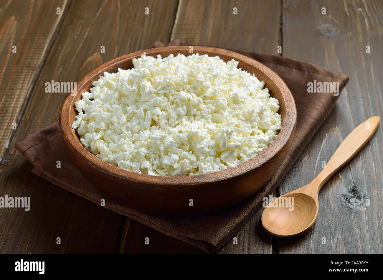 Ricotta, formaggio in ciotola di legno su tavola, vista ravvicinata Foto Stock