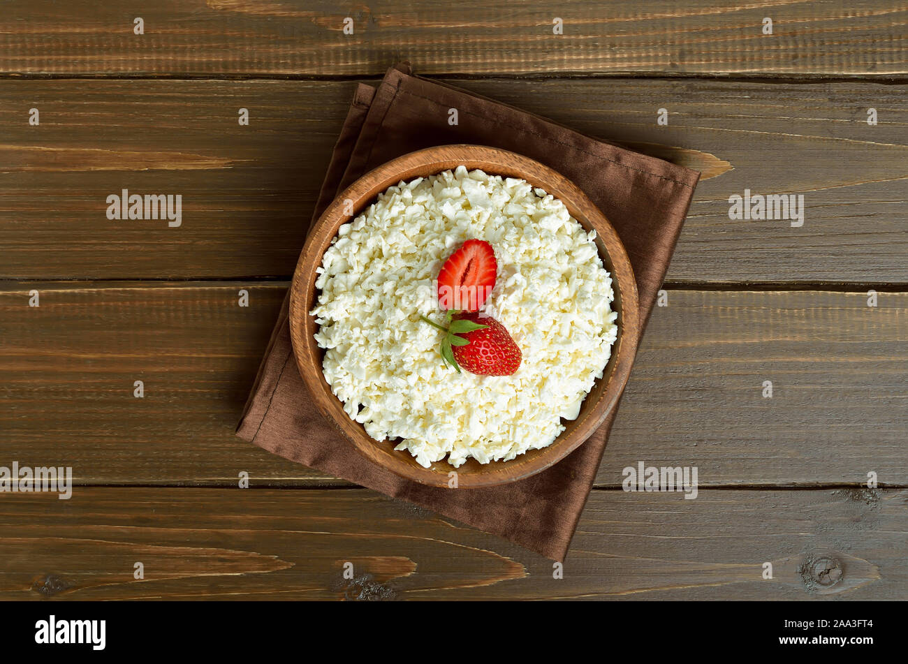 Latticini formaggi, ricotta e fragole in ciotola di legno, vista dall'alto Foto Stock