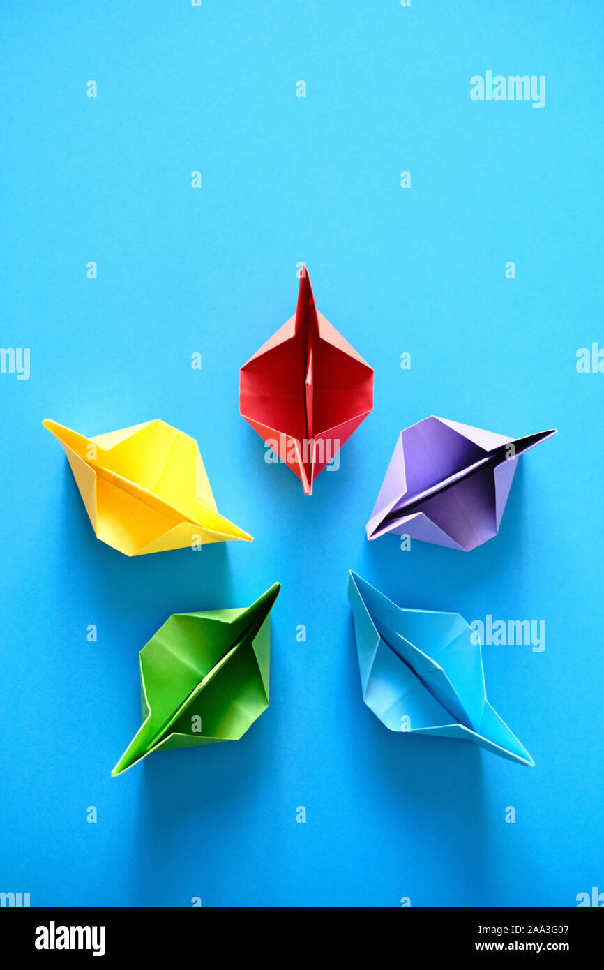 Origami autentiche barche in cerchio su sfondo blu Foto Stock