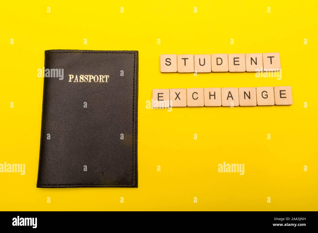 Concetto di viaggio che mostra un passaporto su sfondo giallo con una lettura del segno di scambio di studenti Foto Stock