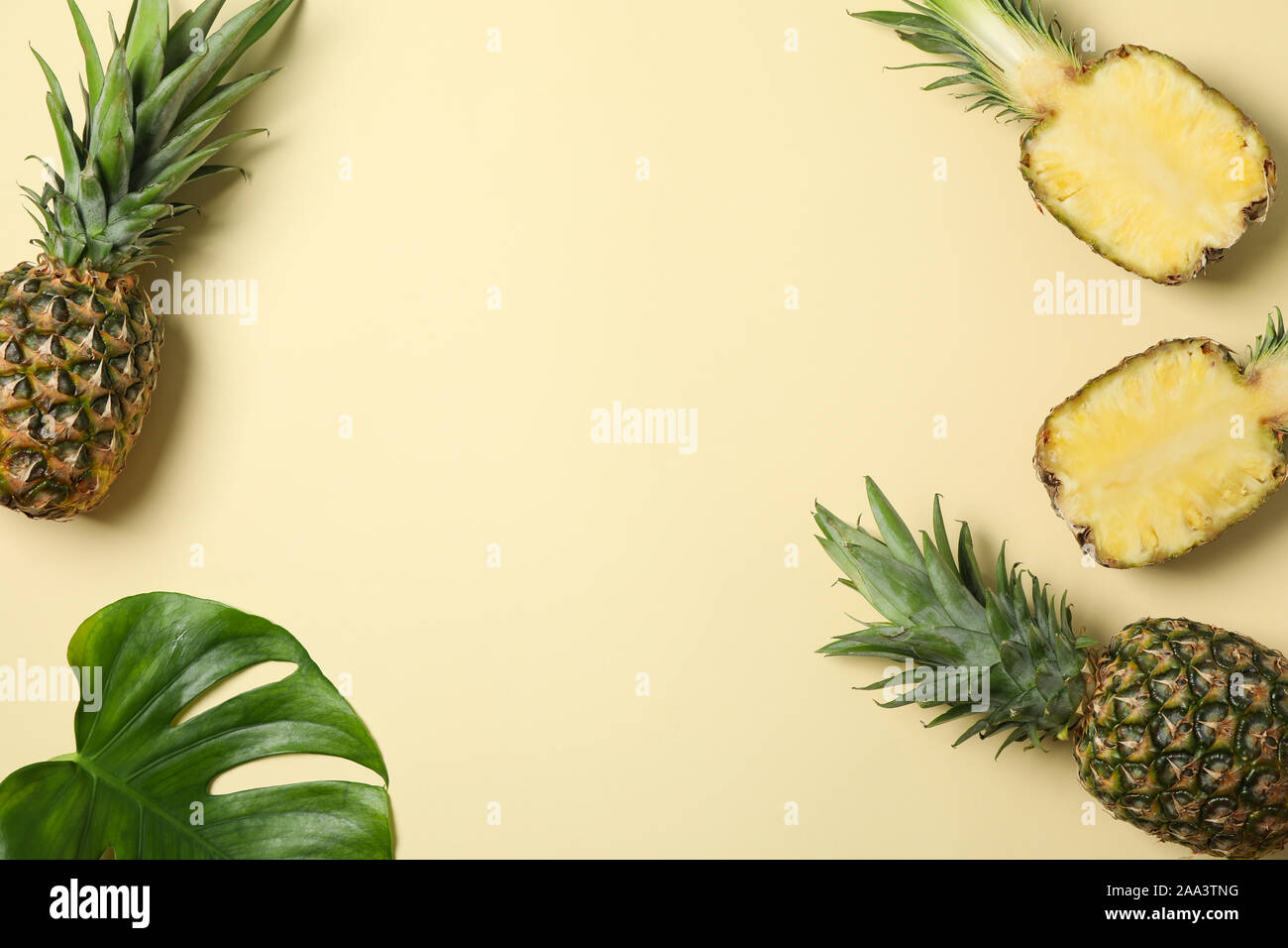Composizione con ananas e foglia di palma su sfondo beige, spazio per il testo Foto Stock