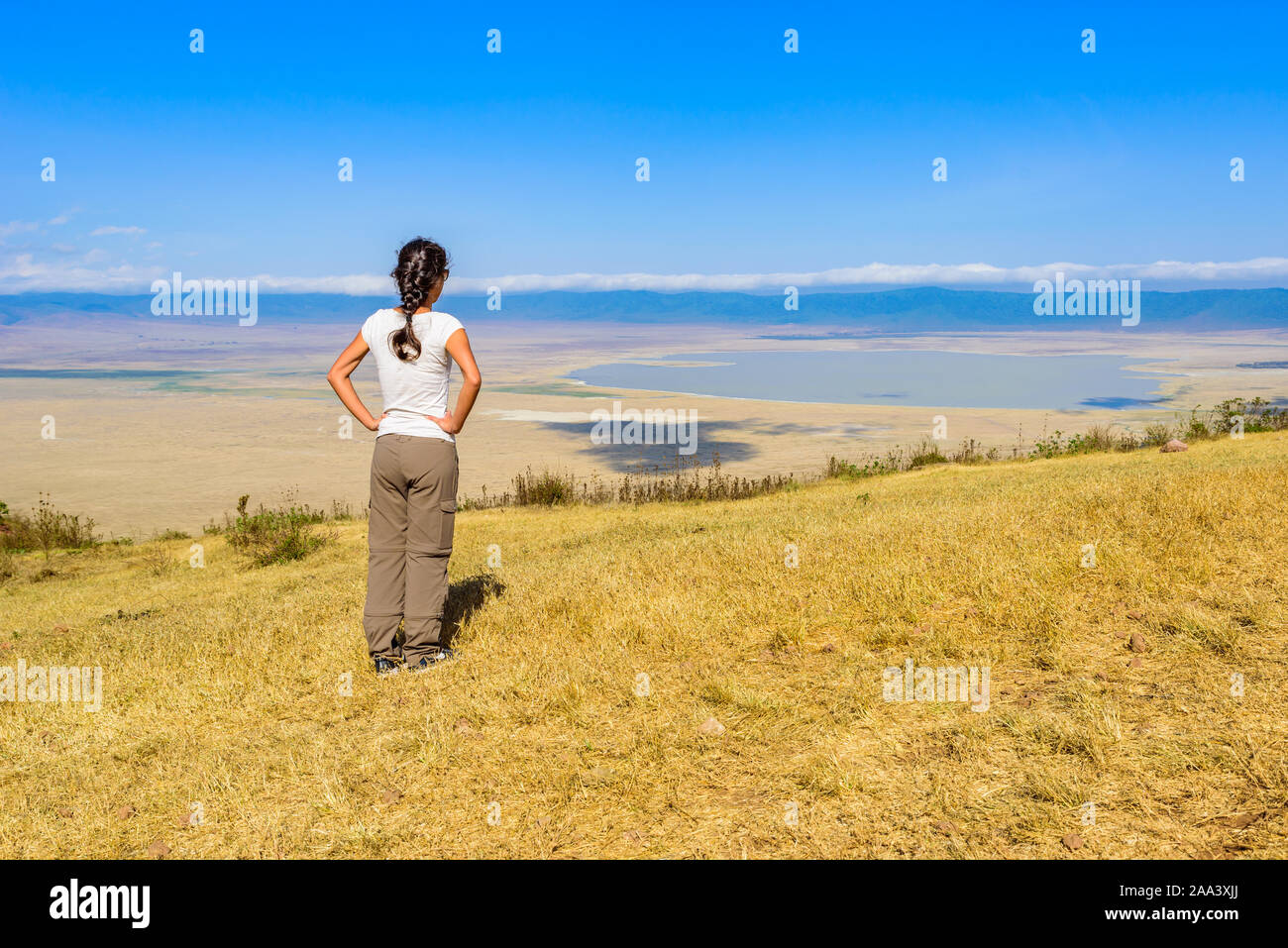 Tourist guarda nel cratere di Ngorongoro Parco nazionale con il Lake Magadi. Tour safari nella savana di Africa. Bellissimo paesaggio paesaggio Tanzan Foto Stock