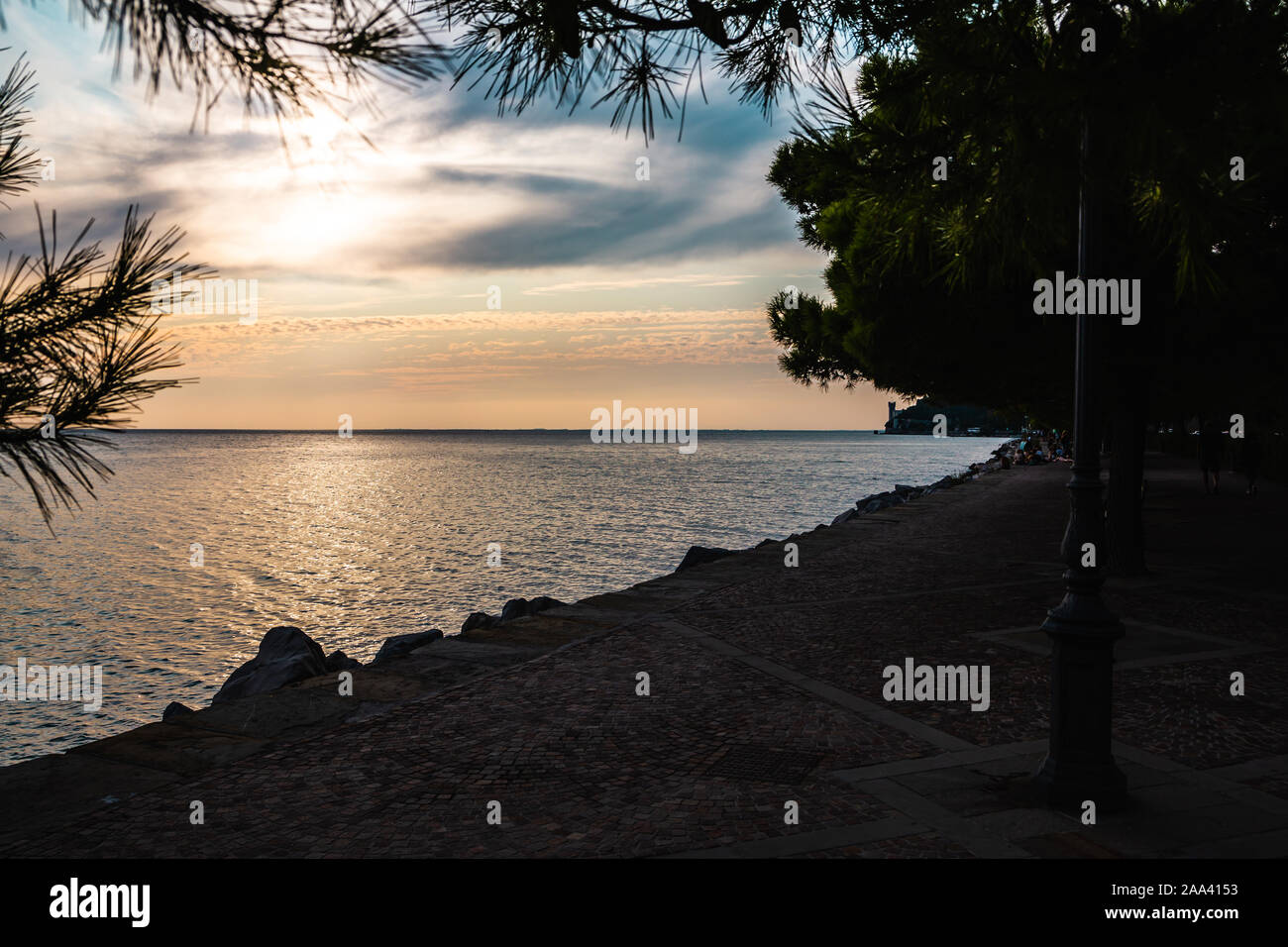 Vista spettacolare della costa del Mare Mediterraneo a Trieste in Italia mentre il tramonto, con il castello di Miramare (Castello di Miramare) in background. Foto Stock