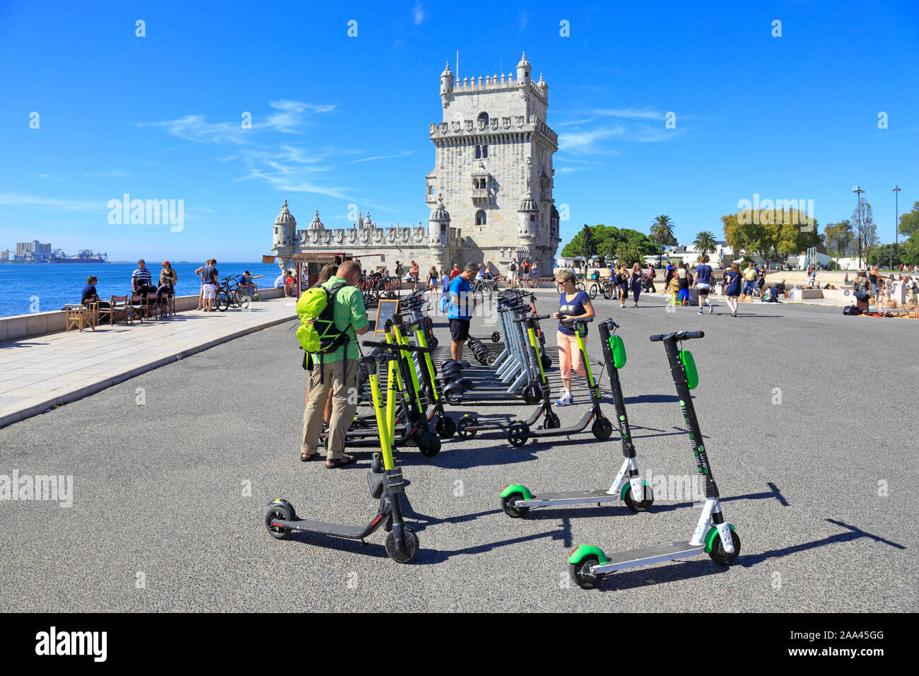 I turisti noleggio di scooter elettrici da la Torre di Belem, ufficialmente la torre di Saint Vincent, un sito Patrimonio Mondiale dell'UNESCO, Lisbona, Portogallo. Foto Stock