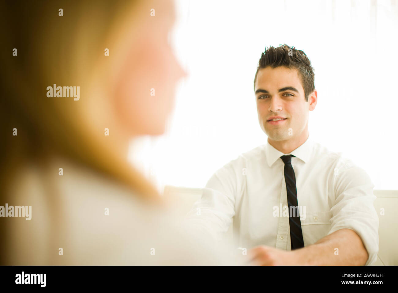 Coppia giovane seduto e parlando Foto Stock