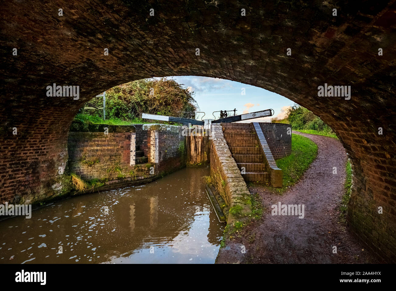 Una vista di una serratura di porta e di percorso di convergenza attraverso un ponte arco sulla serratura Tardebigge Volo, Inghilterra Foto Stock
