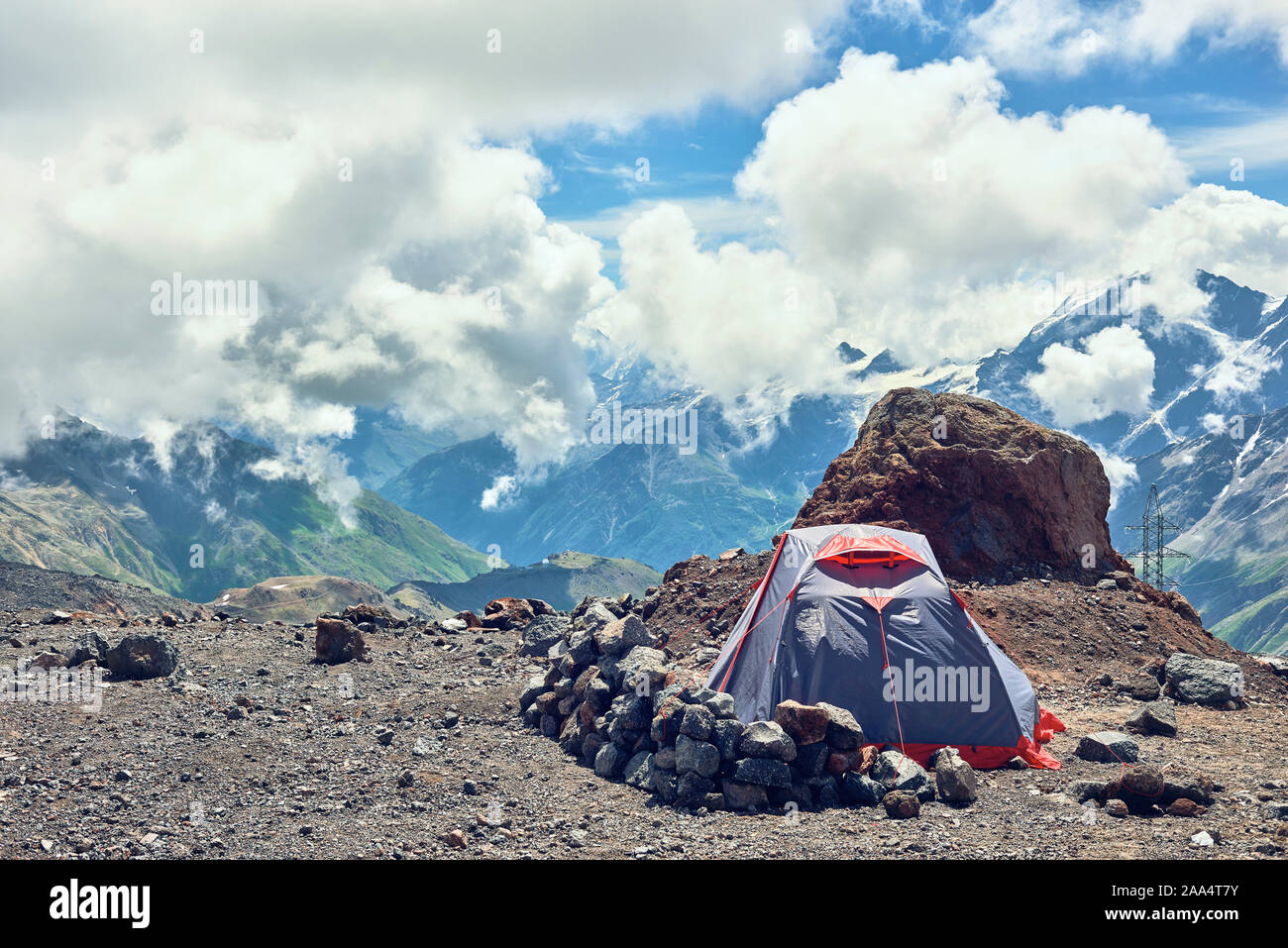 Arrampicatori in tenda in montagna. Sullo sfondo di cime di montagna. Campo alpinista Foto Stock