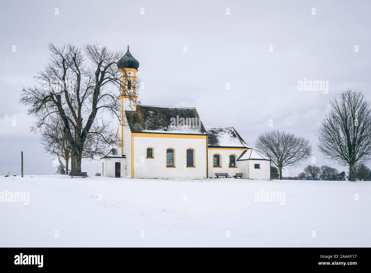 Eine schneebedeckte Kirche in Raisting, Deutschland Foto Stock