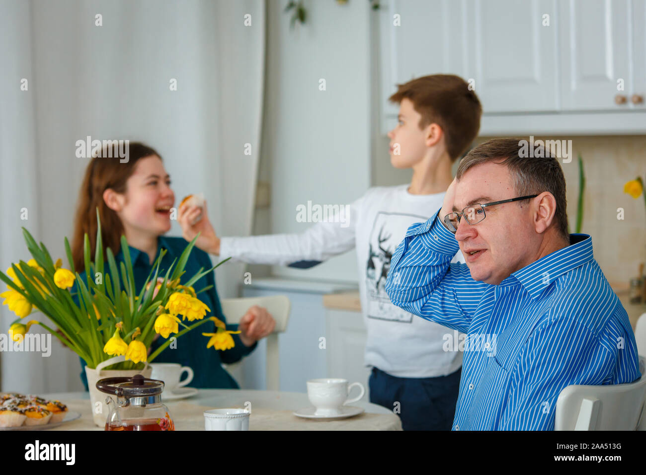 Sessione fotografica - famiglia amichevole. Il papà è preoccupato quando i bambini sono cattivi. Foto Stock