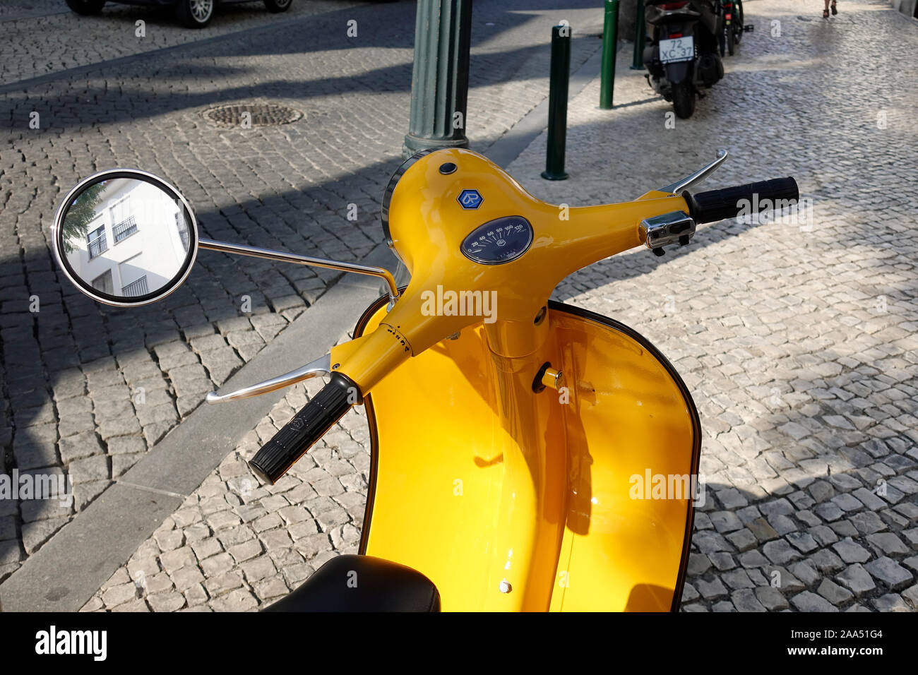 Un giallo brillante scooter Vespa parcheggiata in Cascais Portogallo Foto Stock