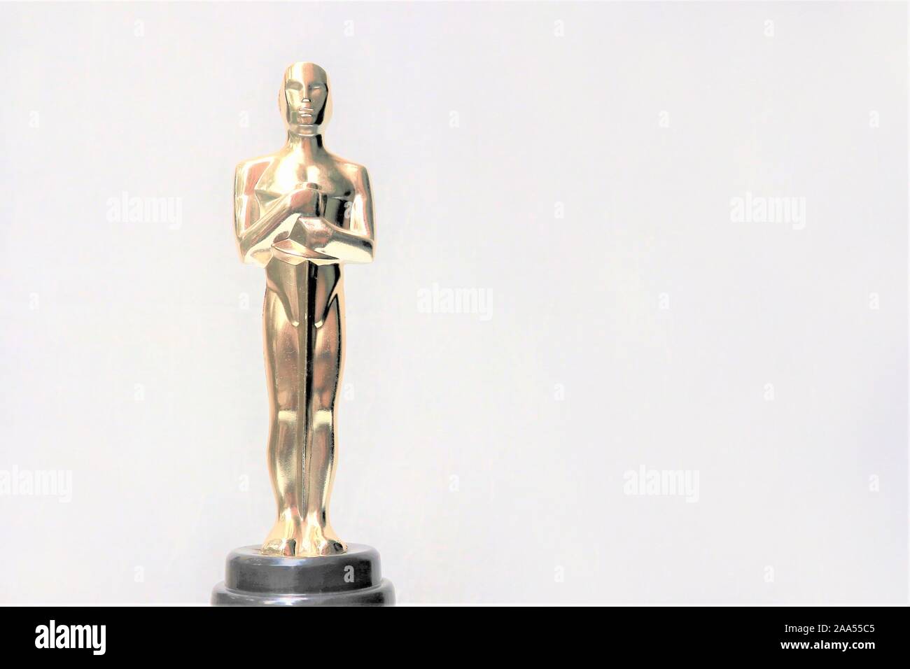 La statua dorata di Oscar su uno sfondo bianco. Il successo e il concetto di vittoria Foto Stock