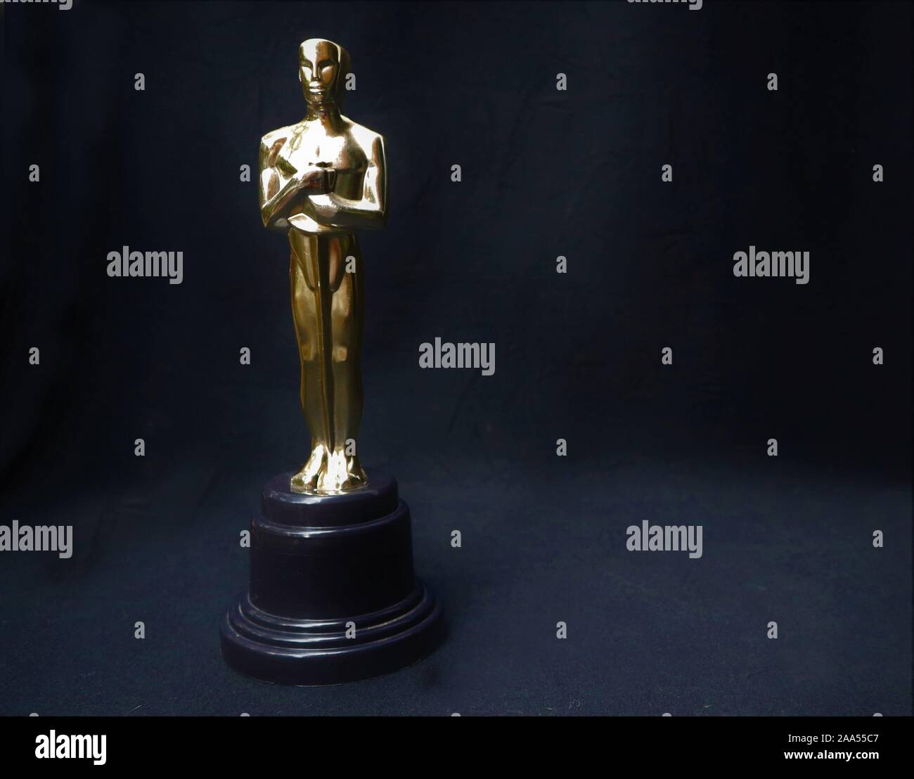 La statua dorata di Oscar su uno sfondo nero. Il successo e il concetto di vittoria Foto Stock