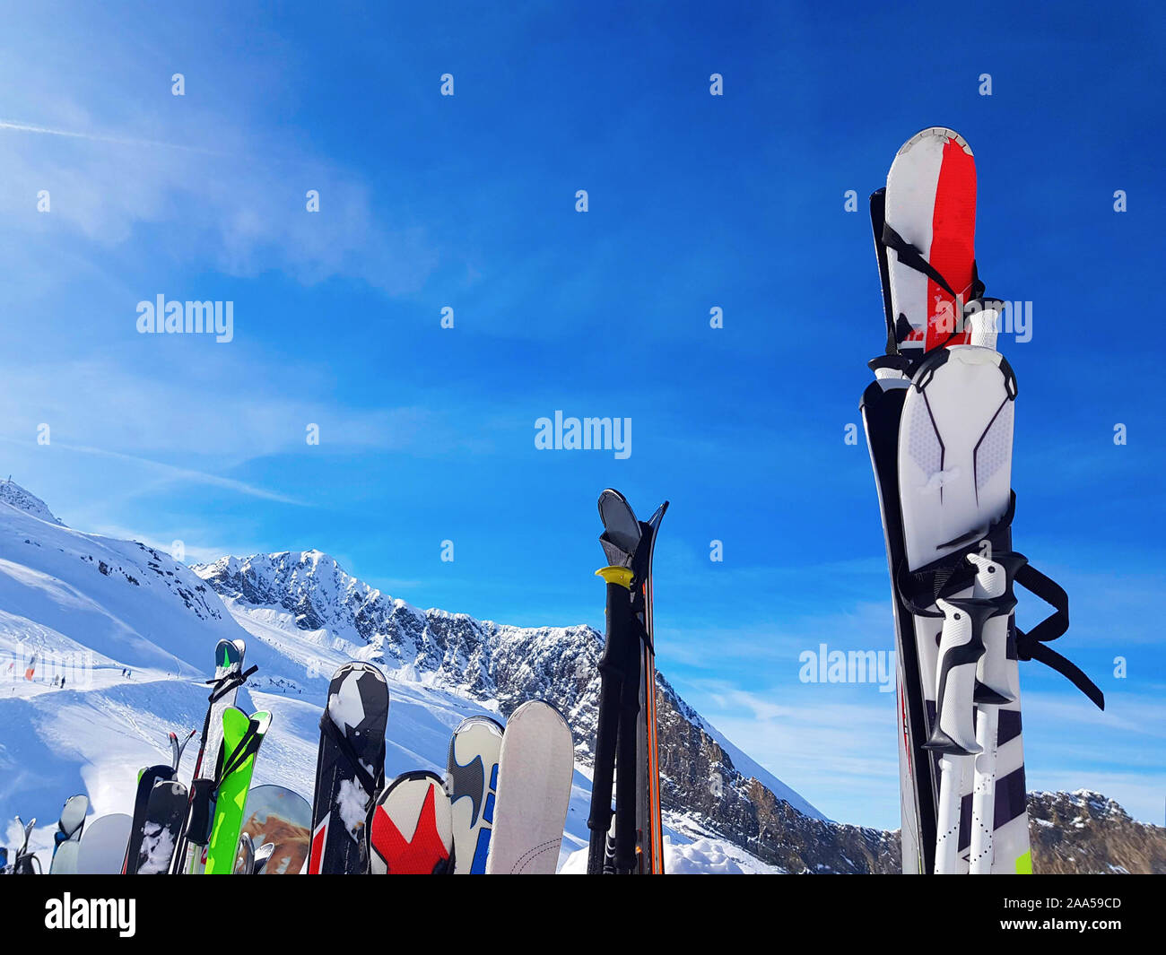 Immagine di multi-colore di sci e snowboard nella neve in inverno resort nel pomeriggio. Sfondo sfocato. Foto Stock