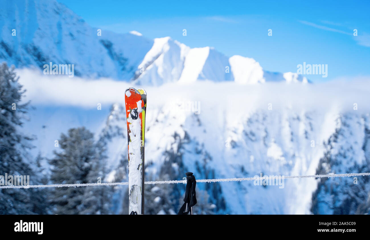 Sci, bastoncini da sci sullo sfondo di montagne innevate in resort sulla giornata invernale Foto Stock