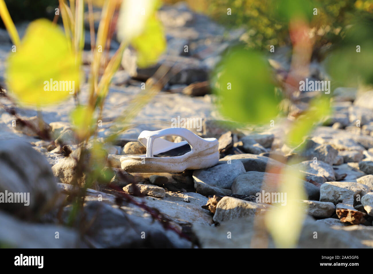 White flip flop perso e da solo sulla riva del fiume Ohio. Foto Stock