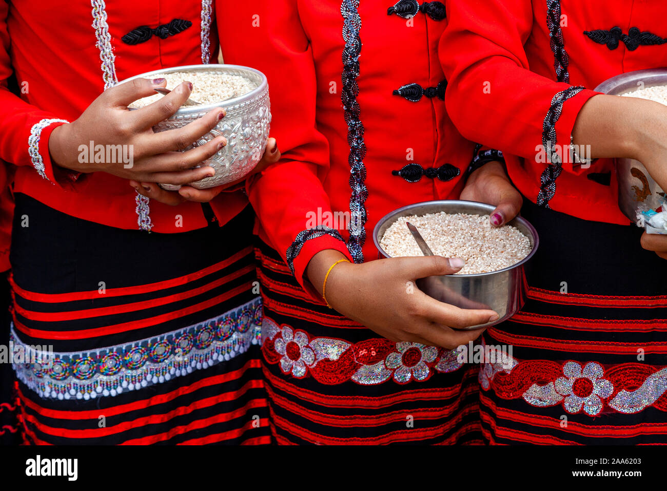 I giovani appartenenti a una minoranza etnica donne attendere l elemosina ai monaci che sono in procinto di prendere parte alla tradizionale processione, Pindaya, Stato Shan, Myanmar Foto Stock