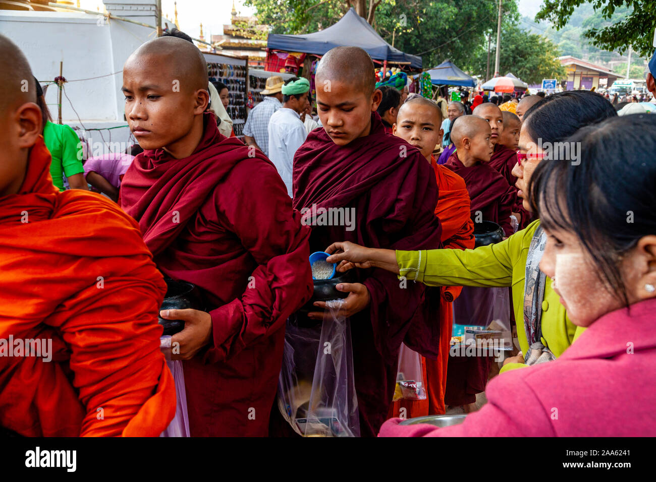 I monaci a piedi giù per la strada principale di Pindaya Cerca Alms durante la grotta di Pindaya Festival, Pindaya, Stato Shan, Myanmar. Foto Stock