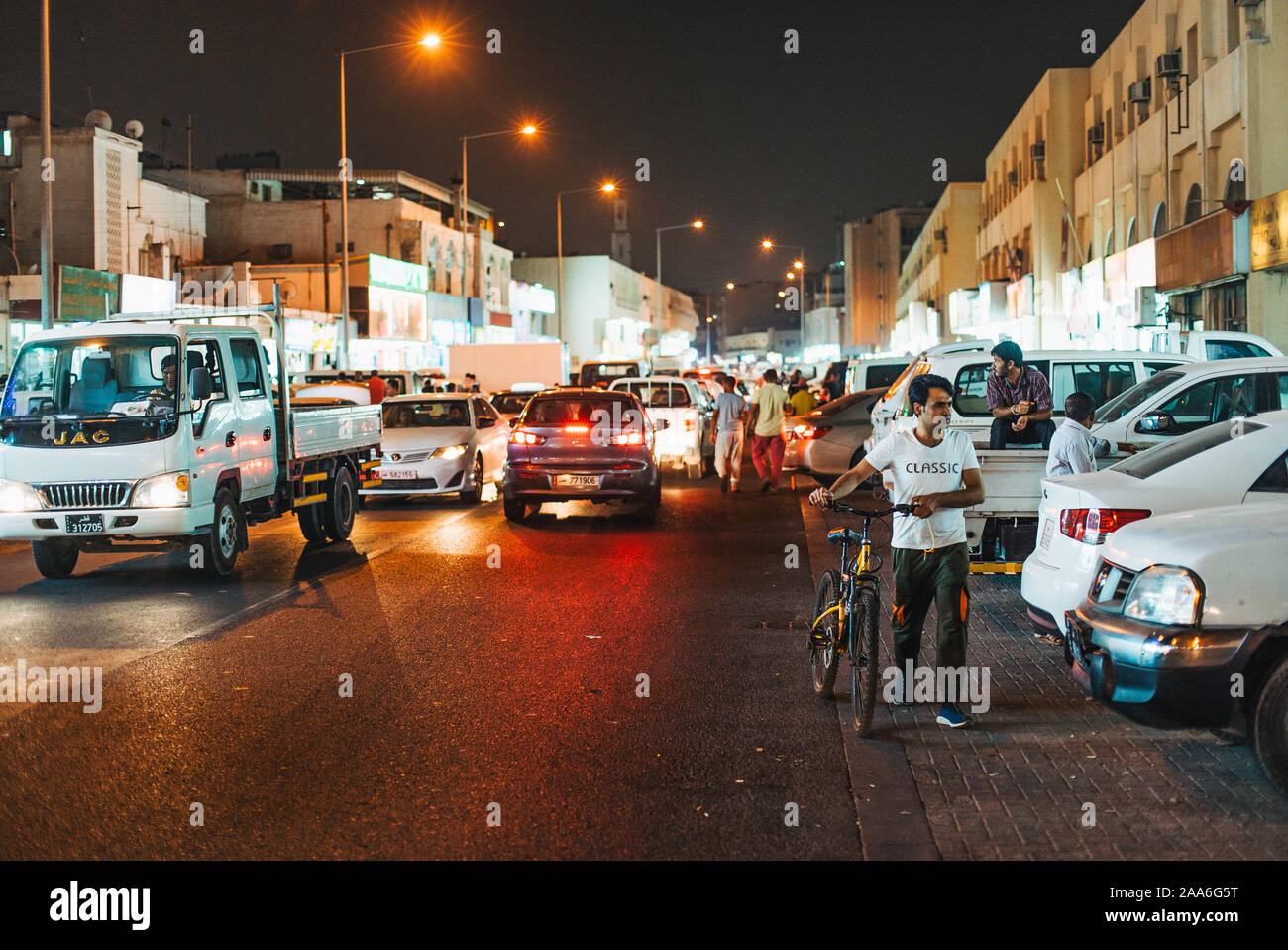 Il traffico e le macchine parcheggiate in strada di notte, nella parte anteriore del Souq Al-Haraj, Doha, Qatar Foto Stock