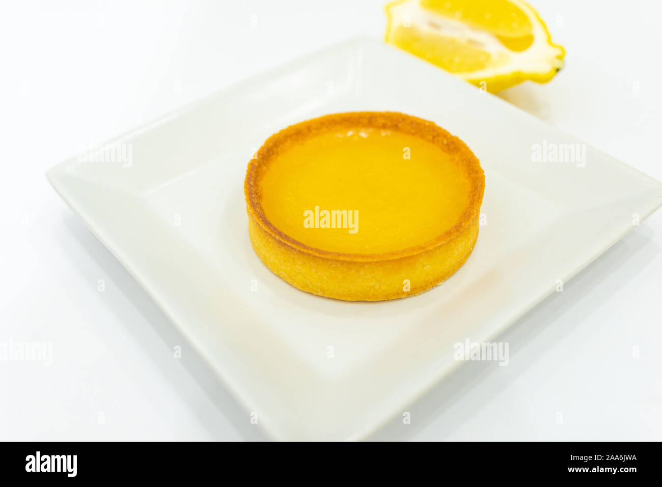 Cagliata di limone Tart sulla piastra. Fatto in casa appena sfornato il cibo. Sfondo bianco, nessun essere umano. Copia vuota spazio per il testo. Foto Stock