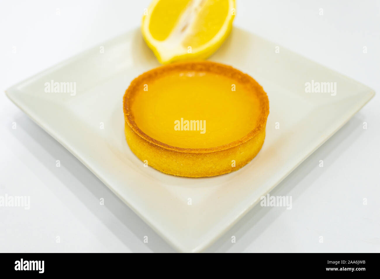 Cagliata di limone Tart sulla piastra. Fatto in casa appena sfornato il cibo. Sfondo bianco, nessun essere umano. Copia vuota spazio per il testo. Foto Stock
