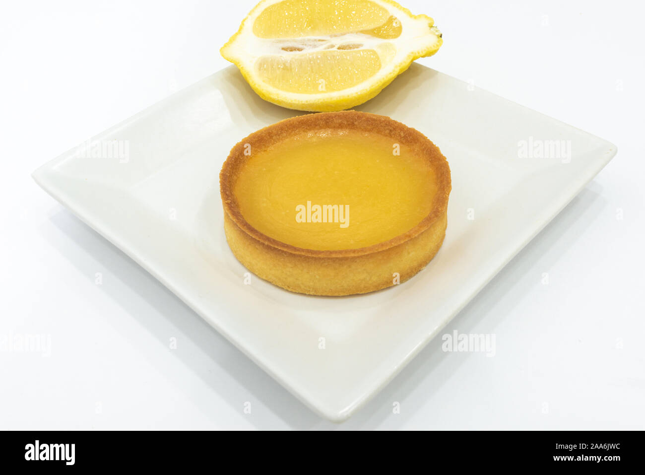 Cagliata di limone Tart sulla piastra. Fatto in casa appena sfornato il cibo. Sfondo bianco, nessun essere umano. Copia vuota spazio per il testo. Foto Stock