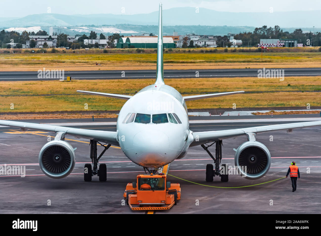 Eseguire aereo agente di rampa accompagna spingere indietro il funzionamento in aeroporto Foto Stock