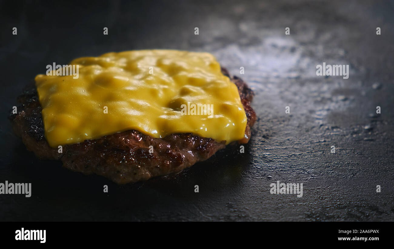 Slow motion costoletta di hamburger con patatine fritte di formaggio Foto Stock Slow motion costoletta di hamburger con patatine fritte di formaggio Foto Stock
