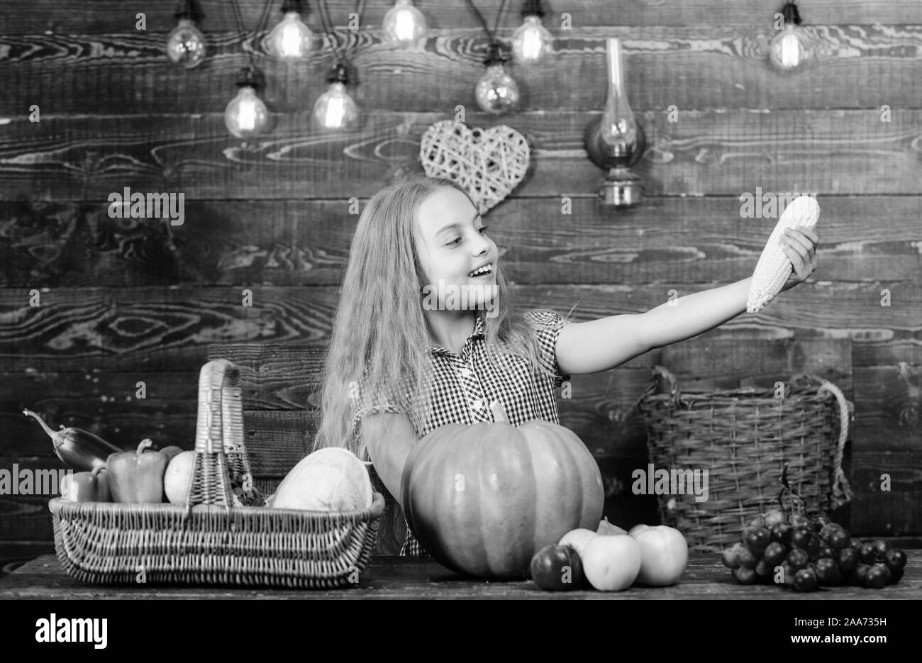 Kid contadino con raccolto lo sfondo di legno. Bambino bambina di godere della vita agricola. Crescere il proprio cibo biologico. Giardinaggio organico. Harvest Festival concetto. Ragazza ragazzo al mercato di fattoria con verdura biologica. Foto Stock