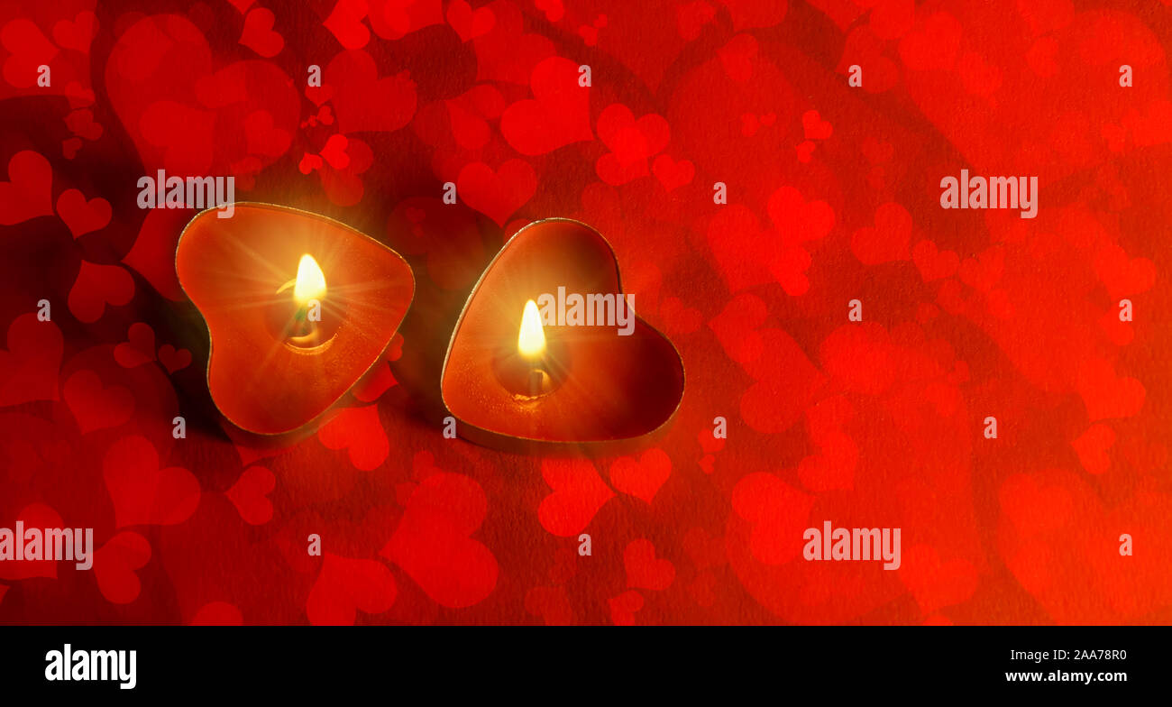 A forma di cuore ad candele il giorno di San Valentino amore sullo sfondo di colore rosso. candela fiamma di amore cuore rosso Foto Stock