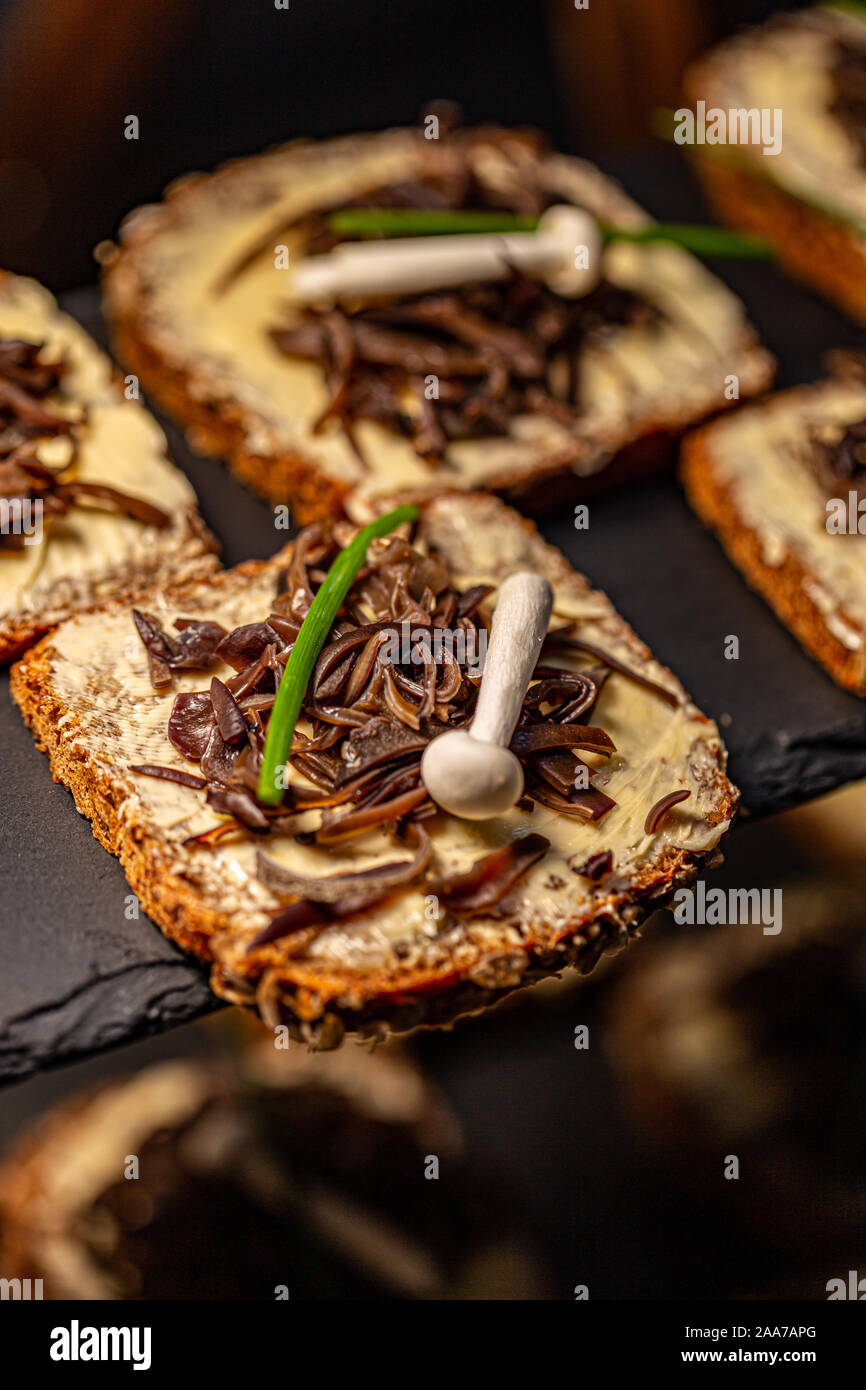 Una sana toast con burro decorate con legno marinato orecchio commestibili e di funghi shimeji Foto Stock
