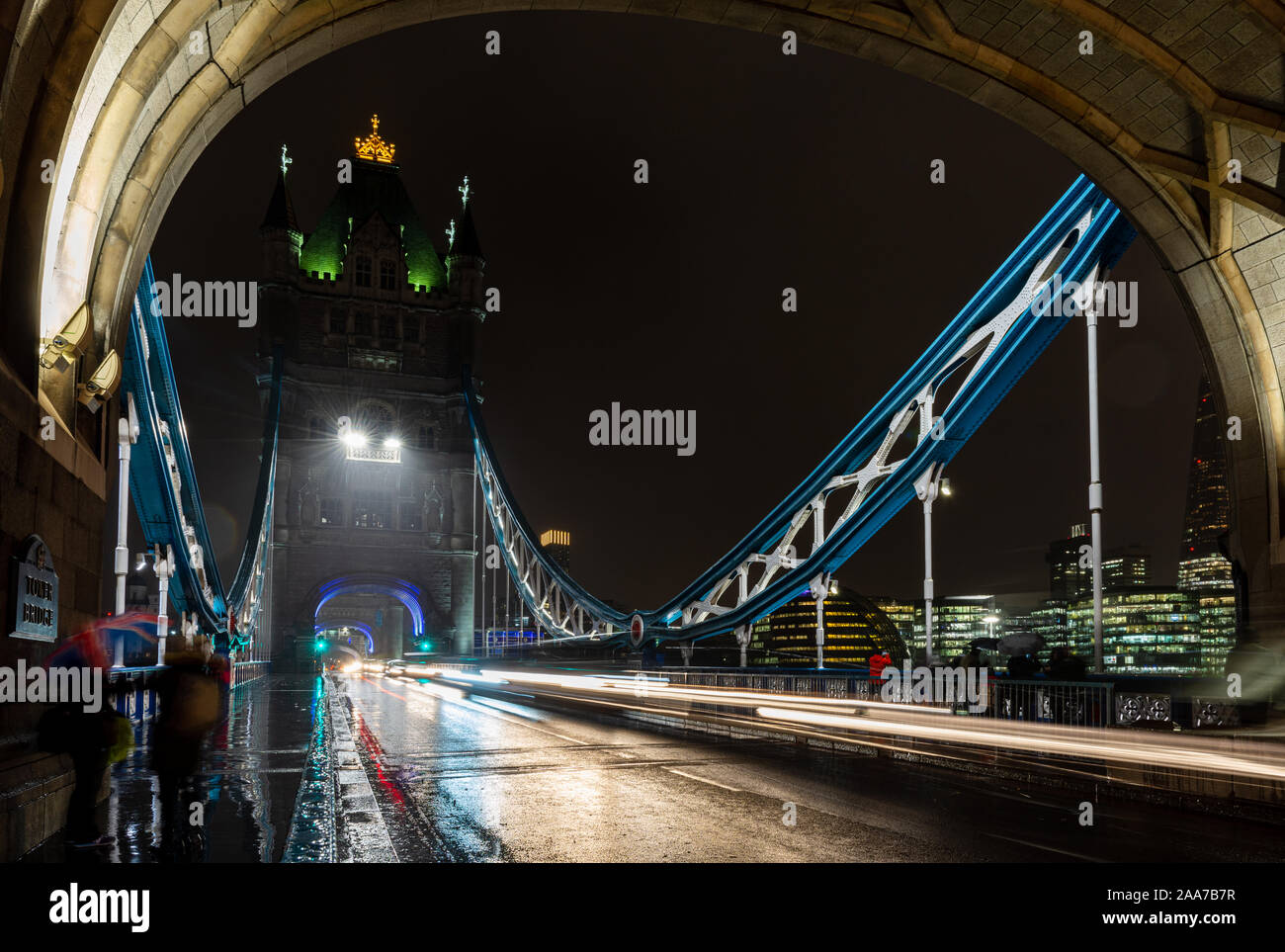 London, England, Regno Unito - 15 Novembre 2019: il traffico si sfoca in percorsi di luce su una notte piovosa il Tower Bridge di Londra. Foto Stock