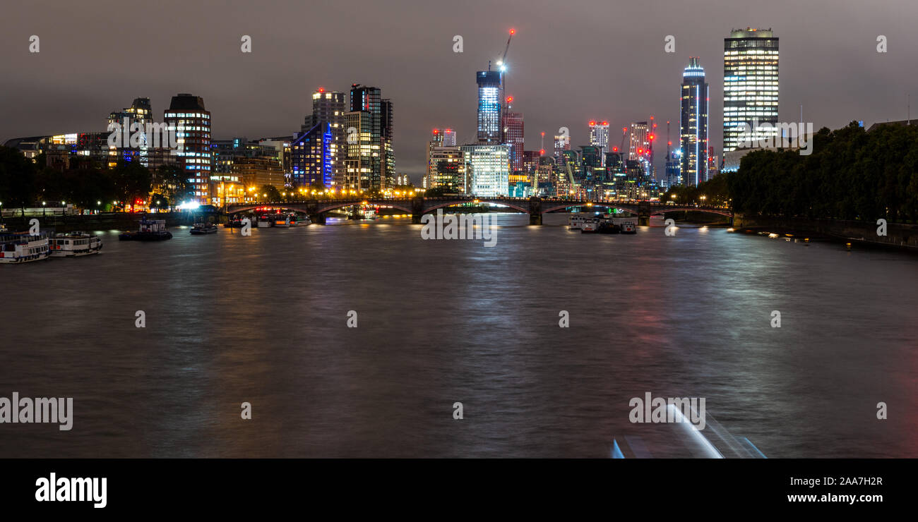 Nuovo blocco uffici e appartamento la costruzione di grattacieli sono illuminata di notte fra gru edili sullo skyline di Vauxhall e Nine Elms regener Foto Stock